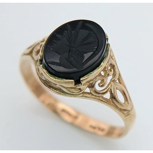 527 - A 9K GOLD RING WITH AN ITAGLIO CENTURIANS HEAD IN ONYX CENTRE STONE .   2 .0gms    size N