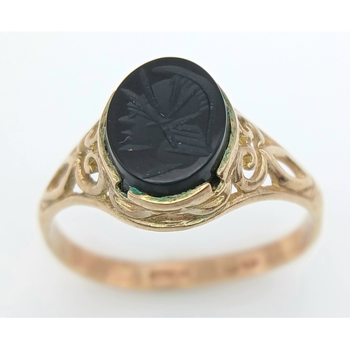 527 - A 9K GOLD RING WITH AN ITAGLIO CENTURIANS HEAD IN ONYX CENTRE STONE .   2 .0gms    size N