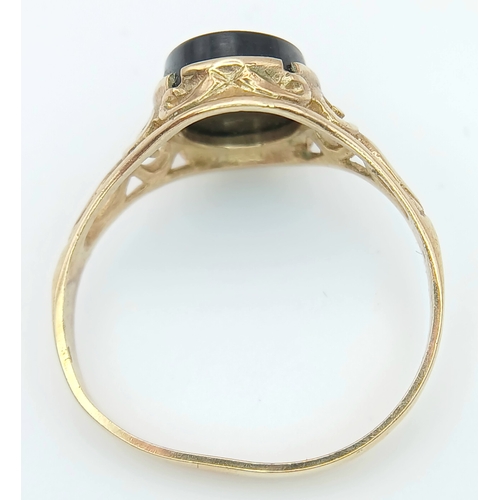 527 - A 9K GOLD RING WITH AN ITAGLIO CENTURIANS HEAD IN ONYX CENTRE STONE .   2 .0gms    size N