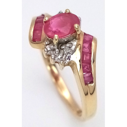 1039 - A 9K Yellow Gold Ruby and Diamond Crossover Ring. Oval and square cut rubies with small diamond acce... 