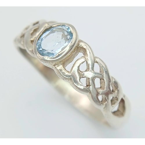 1077 - A Vintage Celtic Design Sterling Silver and Blue Topaz Ring Size S. Set with a 6 x 4mm Oval Cut Blue... 