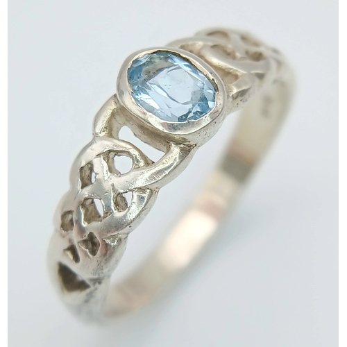1077 - A Vintage Celtic Design Sterling Silver and Blue Topaz Ring Size S. Set with a 6 x 4mm Oval Cut Blue... 