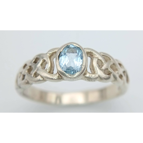1077 - A Vintage Celtic Design Sterling Silver and Blue Topaz Ring Size S. Set with a 6 x 4mm Oval Cut Blue... 