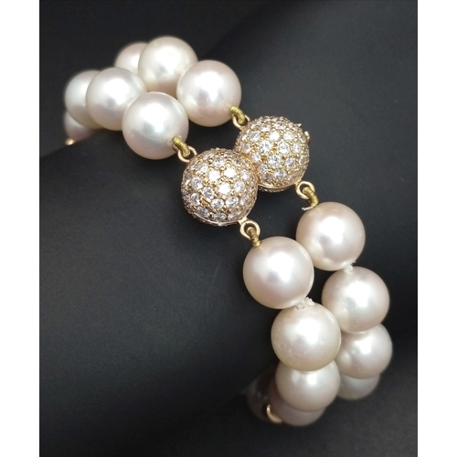A W.G.I. Certified 18K Yellow Gold, Diamond and Akoya Pearl Bracelet. Two rows of round Akoya pearls of 9.5-10mm with a 160ctw. 183 round brilliant cut diamonds of G-H colour and VS1 - VS2 clarity create two fascinating glitterball clasps. 18cm bracelet length. 58.73g total weight.