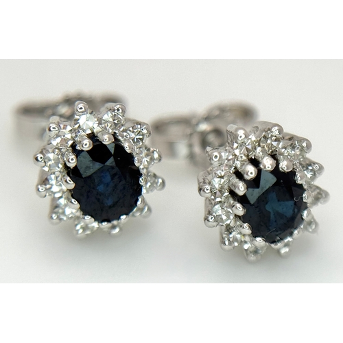 554 - A Pair of 9K White Gold, Sapphire and Diamond Stud Earrings. 2.35g total weight. MT34.