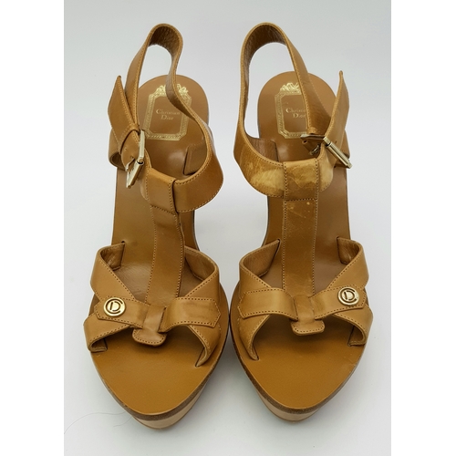 1047 - A Pair of Christian Dior Brown T-Strap Platform Heels. Leather with gold-toned hardware and wood hee... 