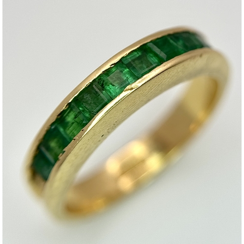 1082 - An 18K Yellow Gold Channel Set Emerald Ring. Size O. Nine square shaped emeralds. 5.8g. N10/24756.