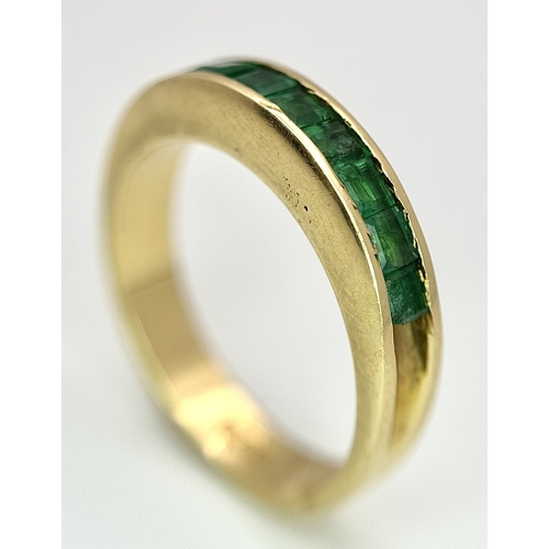 1082 - An 18K Yellow Gold Channel Set Emerald Ring. Size O. Nine square shaped emeralds. 5.8g. N10/24756.