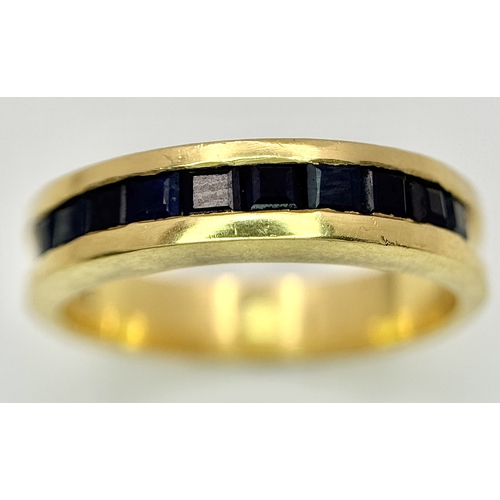 1117 - An 18K Yellow Gold Sapphire Channel Set Ring. 10 square cut sapphires. Size N. 5.4g. NL-2440.