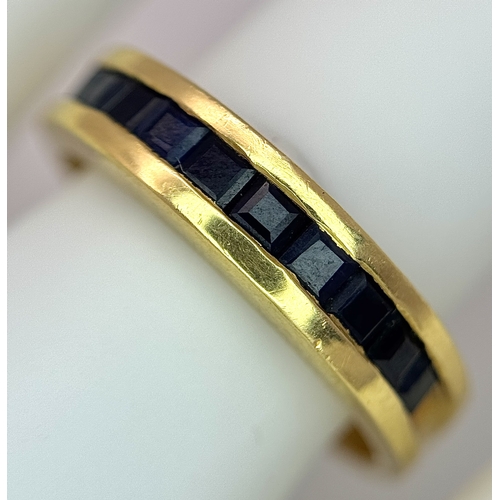 1117 - An 18K Yellow Gold Sapphire Channel Set Ring. 10 square cut sapphires. Size N. 5.4g. NL-2440.