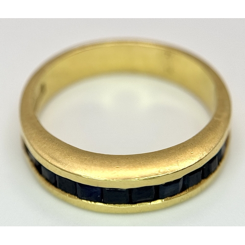 1117 - An 18K Yellow Gold Sapphire Channel Set Ring. 10 square cut sapphires. Size N. 5.4g. NL-2440.