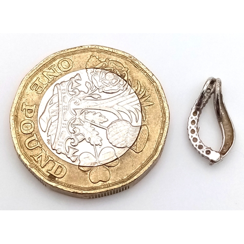1067 - An 18K Gold (tests as) and Diamond Pendant. 0.5g.