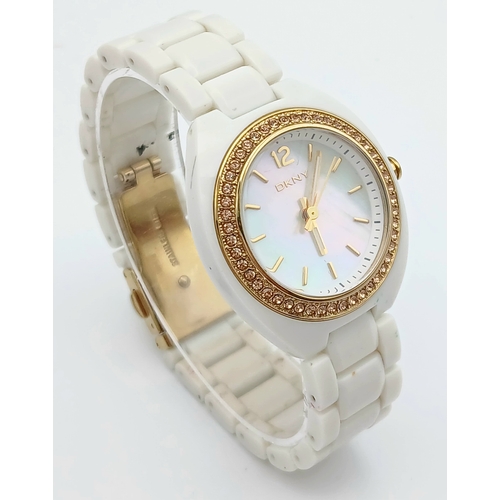 1071 - A DKNY, STONE SET, WHITE WITH GOLD TONE ACCENTS BRACELET WATCH. IN FULL WORKING ORDER. NEW BATTERY F... 