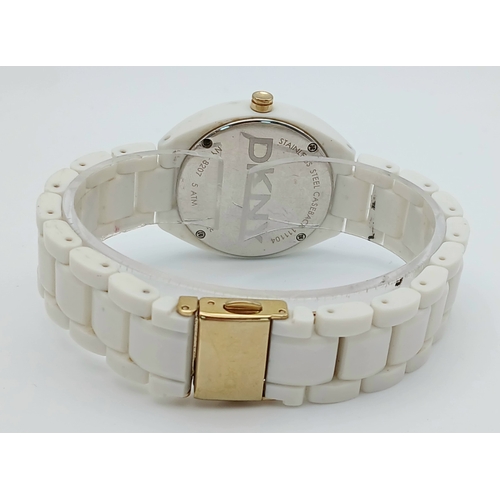 1071 - A DKNY, STONE SET, WHITE WITH GOLD TONE ACCENTS BRACELET WATCH. IN FULL WORKING ORDER. NEW BATTERY F... 