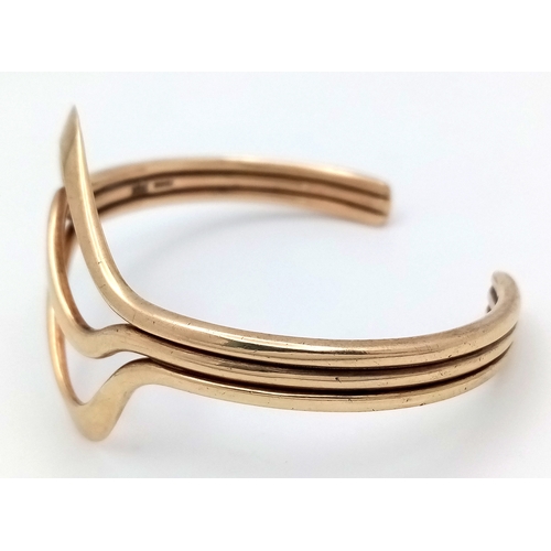 1108 - A 9K Yellow Gold Swirl Cuff Bangle. 22.65g.
