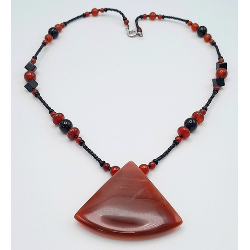1100 - A red agate and hematite necklace with 925 silver clasp.
Approx 50cm length. Please see photos for d... 