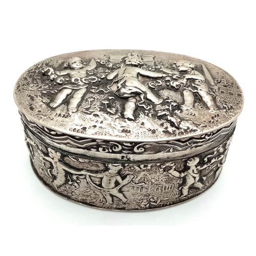 396 - An Antique Silver (800 Purity) German/Dutch Trinket Box. Repoussé decorative work of children playin... 