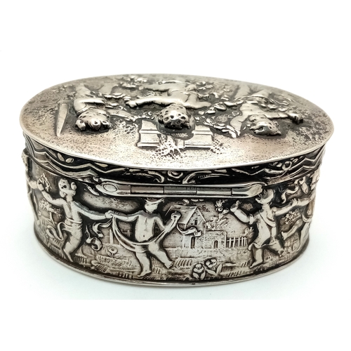 396 - An Antique Silver (800 Purity) German/Dutch Trinket Box. Repoussé decorative work of children playin... 