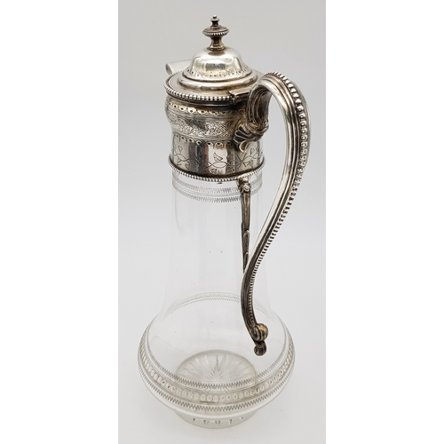 141 - An Antique Victorian Cut Glass Claret Jug with Sterling Silver Scrolled Handle, Lid with ornate fini... 