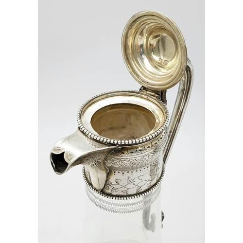 141 - An Antique Victorian Cut Glass Claret Jug with Sterling Silver Scrolled Handle, Lid with ornate fini... 