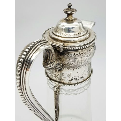141 - An Antique Victorian Cut Glass Claret Jug with Sterling Silver Scrolled Handle, Lid with ornate fini... 
