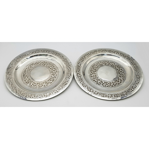 386 - A Pair of 800 Silver Decorative Chased Plates. Intricate foliate patterns along the border and centr... 