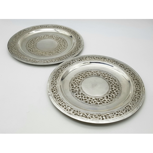 386 - A Pair of 800 Silver Decorative Chased Plates. Intricate foliate patterns along the border and centr... 
