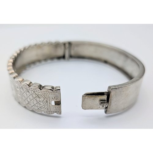 403 - A Vintage Sterling Silver Hinged Bangle Bracelet with a Detailed Engraved Foliage Pattern. Unhallmar... 
