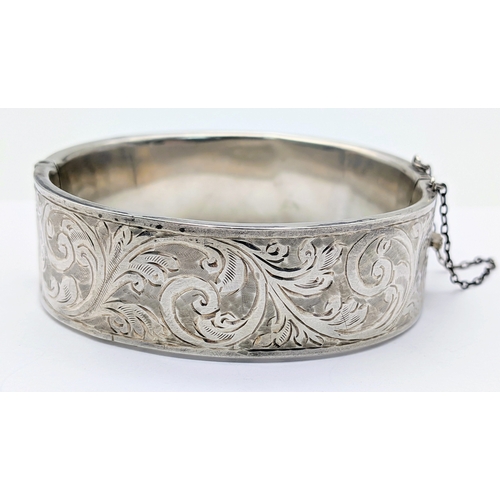 417 - An Antique Engraved Sterling Silver Hinged Bangle Bracelet with Foliate Design and a Safety Chain. H... 