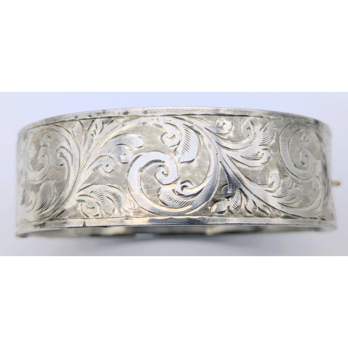 417 - An Antique Engraved Sterling Silver Hinged Bangle Bracelet with Foliate Design and a Safety Chain. H... 
