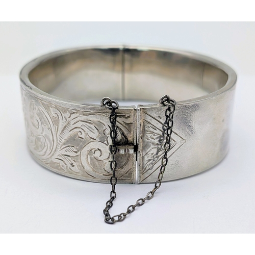 417 - An Antique Engraved Sterling Silver Hinged Bangle Bracelet with Foliate Design and a Safety Chain. H... 