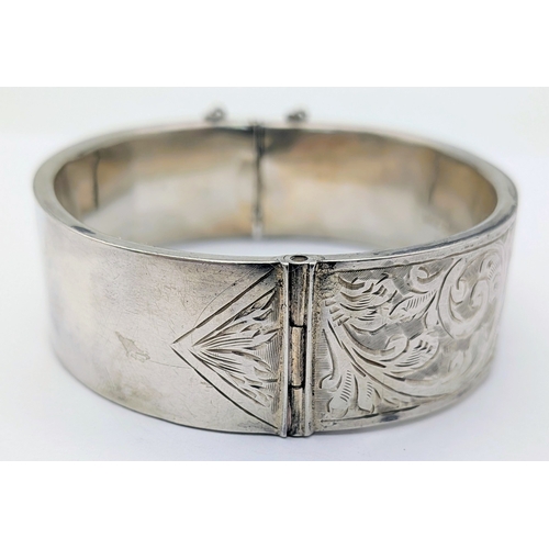 417 - An Antique Engraved Sterling Silver Hinged Bangle Bracelet with Foliate Design and a Safety Chain. H... 