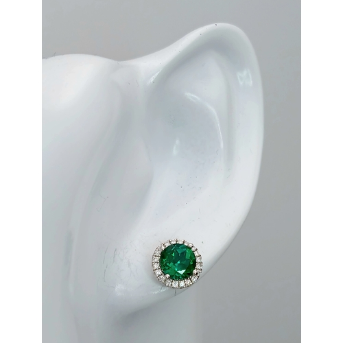 287 - A pair of 14K White Gold, Diamond And Synthetic Emerald Set, Halo Stud Earrings. 2.2G. Tan 6009