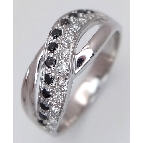 149 - An 18K White Gold Sapphire and Diamond Crossover Ring. Size N. 4g. Ref: 26431.
