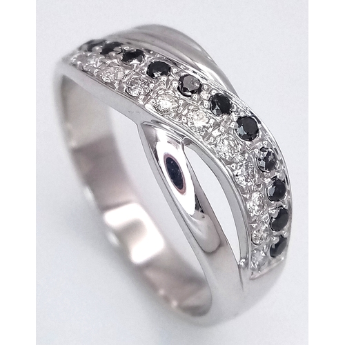 149 - An 18K White Gold Sapphire and Diamond Crossover Ring. Size N. 4g. Ref: 26431.