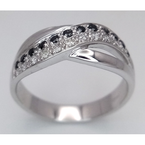 149 - An 18K White Gold Sapphire and Diamond Crossover Ring. Size N. 4g. Ref: 26431.