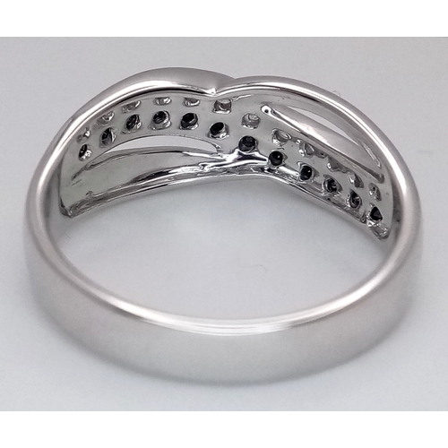 149 - An 18K White Gold Sapphire and Diamond Crossover Ring. Size N. 4g. Ref: 26431.