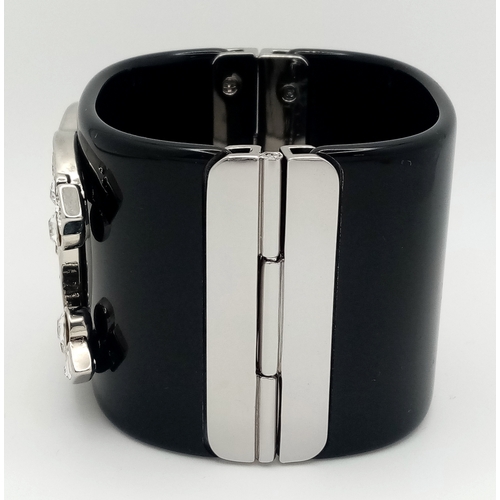 125 - A Chanel Black CC Embellished Cuff Bangle. Set with white stones. 5.5cm width. 58mm inner diameter. ... 