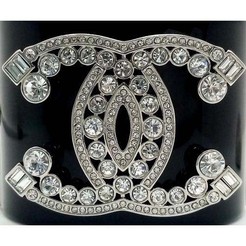125 - A Chanel Black CC Embellished Cuff Bangle. Set with white stones. 5.5cm width. 58mm inner diameter. ... 