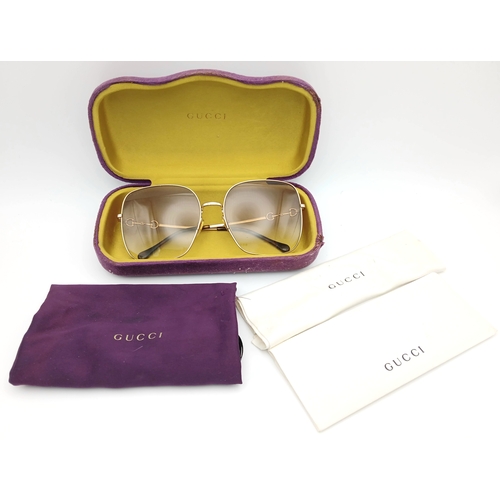 484 - A Pair of Gucci GG0879S Brown Sunglasses. Gold-toned frames with horsebit detailing. Comes with case... 
