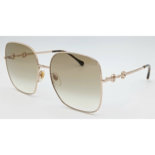 484 - A Pair of Gucci GG0879S Brown Sunglasses. Gold-toned frames with horsebit detailing. Comes with case... 