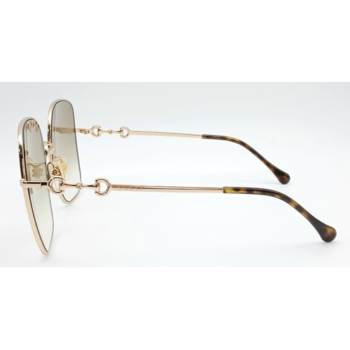 484 - A Pair of Gucci GG0879S Brown Sunglasses. Gold-toned frames with horsebit detailing. Comes with case... 