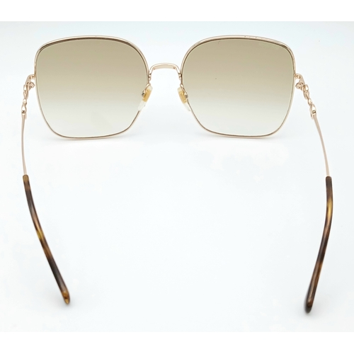 484 - A Pair of Gucci GG0879S Brown Sunglasses. Gold-toned frames with horsebit detailing. Comes with case... 