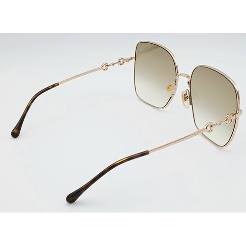 484 - A Pair of Gucci GG0879S Brown Sunglasses. Gold-toned frames with horsebit detailing. Comes with case... 