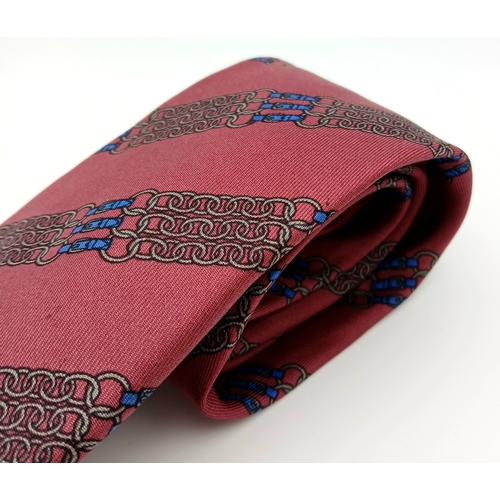 498 - An Hermès silk tie. Crafted in burgundy silk featuring a repeating chain and link motif in contrasti... 