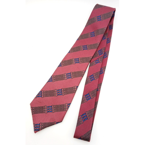 498 - An Hermès silk tie. Crafted in burgundy silk featuring a repeating chain and link motif in contrasti... 