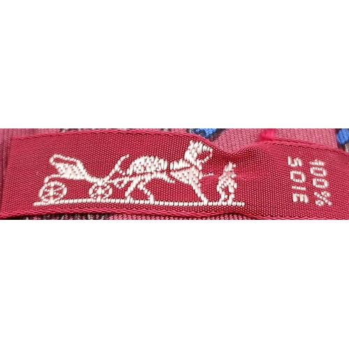 498 - An Hermès silk tie. Crafted in burgundy silk featuring a repeating chain and link motif in contrasti... 