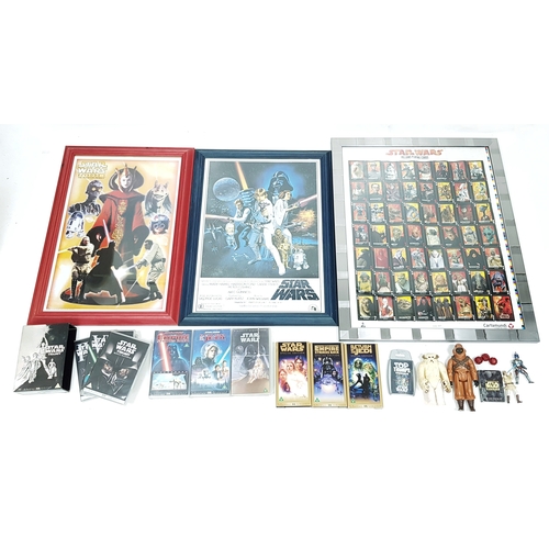 81 - A bundle of Star Wars collectables. To include three framed posters, VHS videos, DVD's, figures and ... 