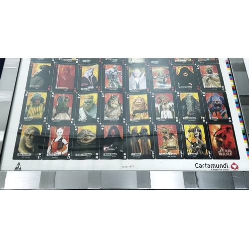 81 - A bundle of Star Wars collectables. To include three framed posters, VHS videos, DVD's, figures and ... 