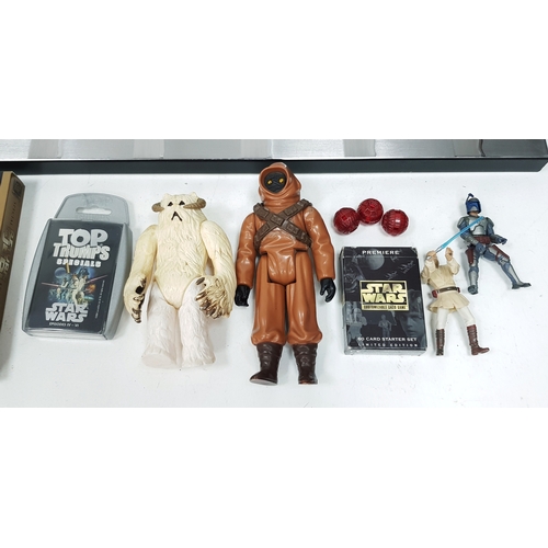 81 - A bundle of Star Wars collectables. To include three framed posters, VHS videos, DVD's, figures and ... 